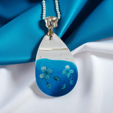 Beautiful blue and clear resin pendant with flower details