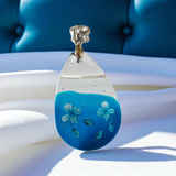 Beautiful blue and clear resin pendant with flower details