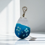 Beautiful blue and clear resin pendant with flower details